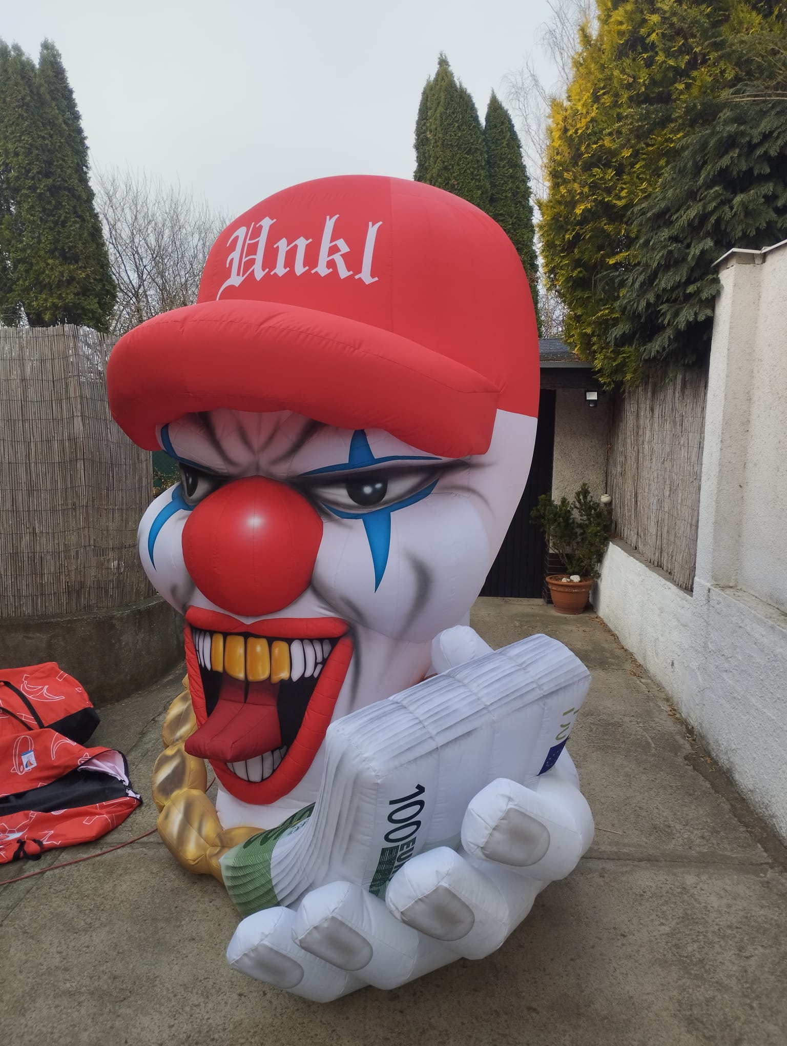Inflatable clown with a red cap and money for Bonez MC